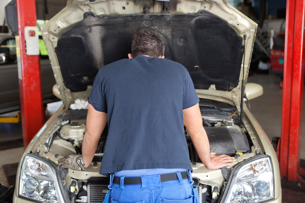 He repairs his car. Механик сзади. Механическая работа машины. Кантовать автомобиль. Замена людей машинами.