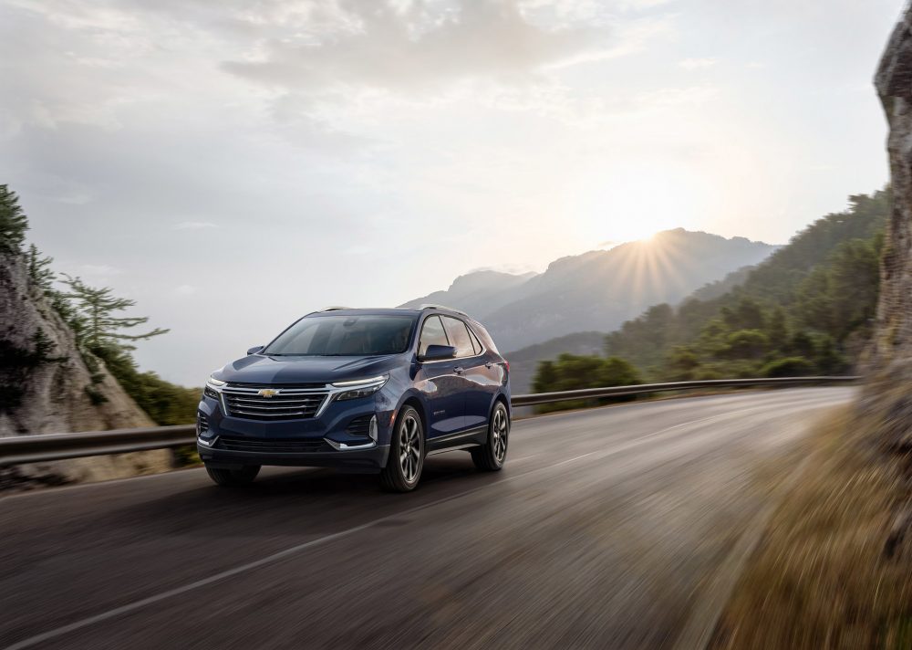 Front side view of 2021 Chevrolet Equinox Premier driving on mountain road