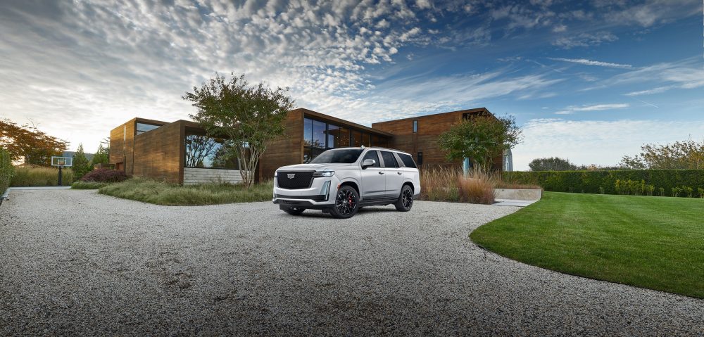 2021 Cadillac Escalade parked outside a contemporary house on a gravel driveway