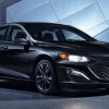 Black 2021 Chevrolet Malibu parked in front of a modern building