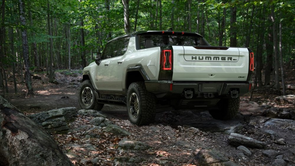 The GMC Hummer EV off-roading in a forest