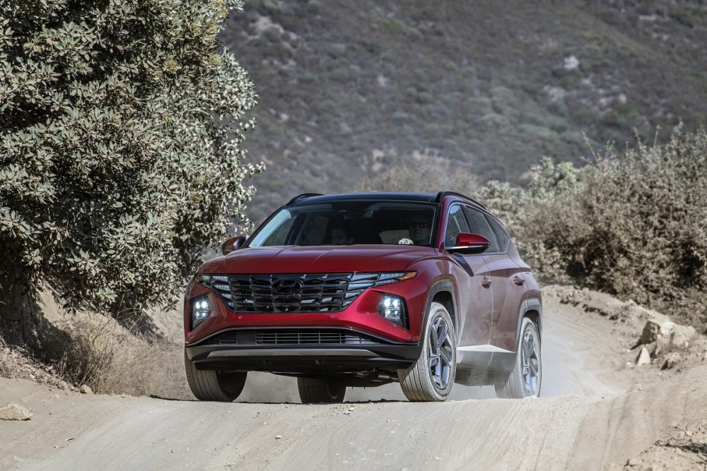 Front view of 2022 Hyundai Tucson driving on dusty mountain road