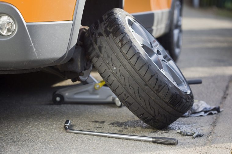 Tire Leaning Against Car with Jack and Tire Iron