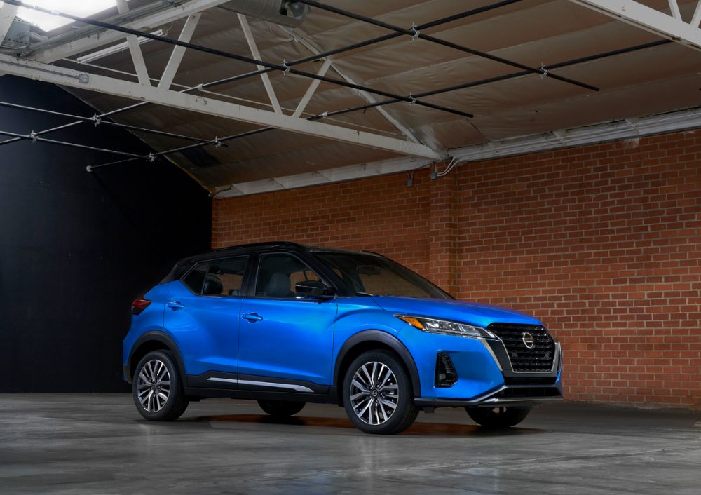 Blue 2021 Nissan Kicks parked inside a garage next to a brick wall