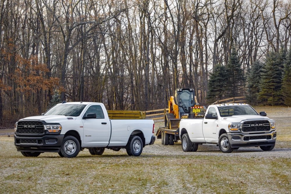 The 2021 Ram 2500 and Ram 3500 parked in front of a forest