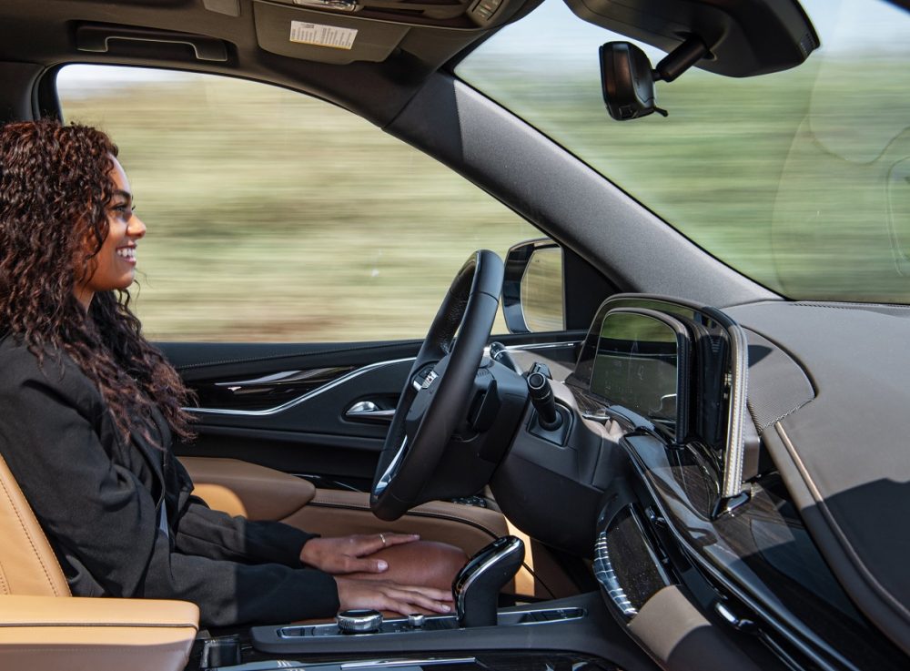 A woman sitting in the driver's seat with her hands on her lap as Super Cruise works