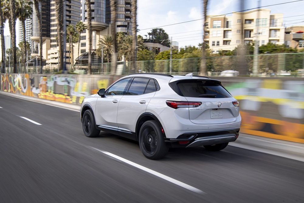 Rear side view of 2021 Buick Envision driving down city street