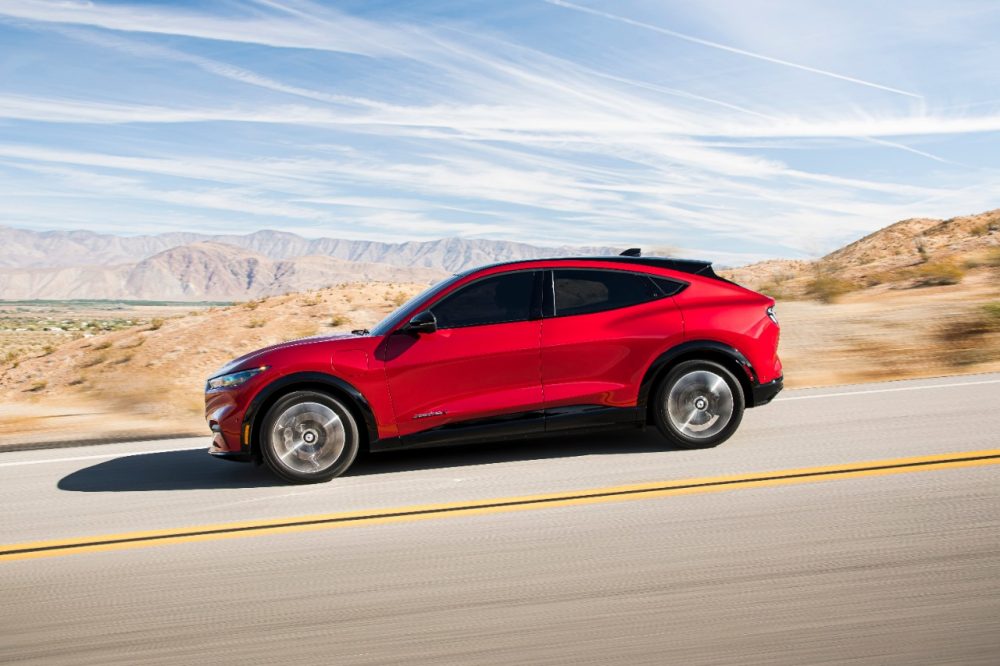 2021 Ford Mustang Mach-E from the side in motion down a road along the desert 