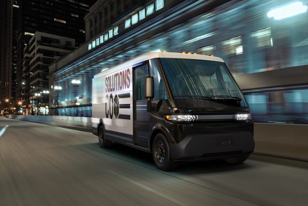 BrightDrop EV600 electric delivery van driving down city street at night