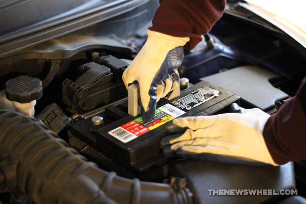 Installing new car battery in engine