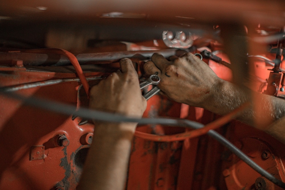 Hands repairing a vehicle intended to evoke RV service technicians