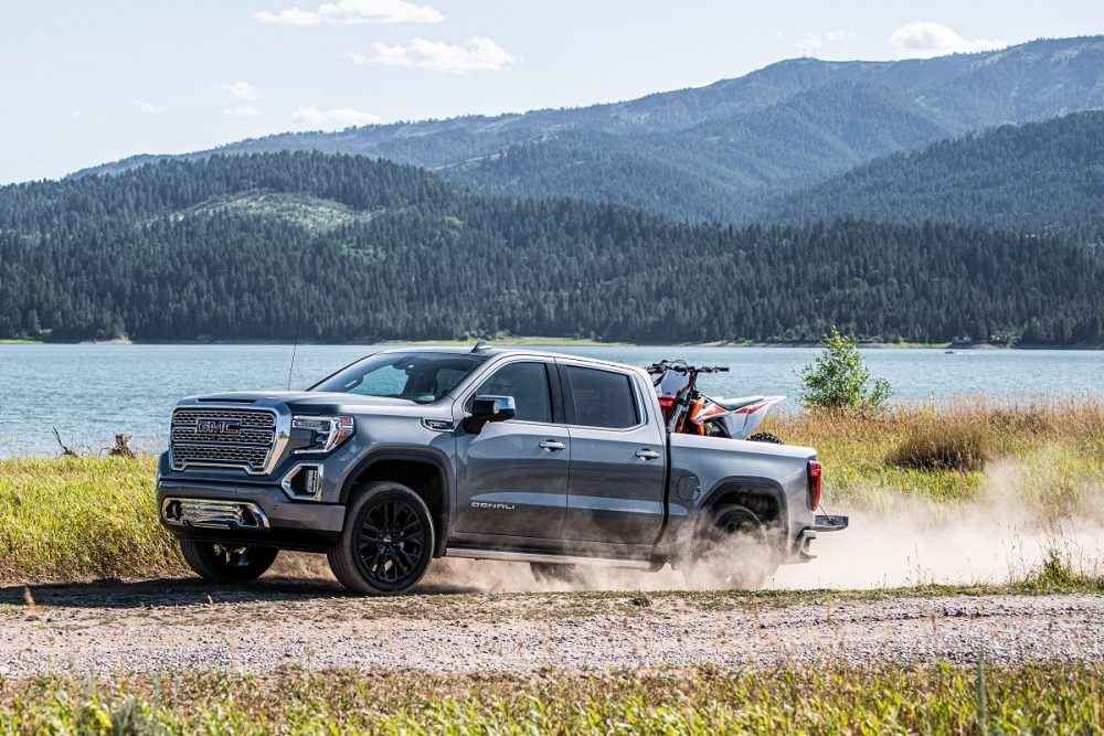 The 2021 GMC Sierra 1500 Denali carrying an ATV by a lake