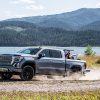 Side view of 2021 GMC Sierra 1500 Denali in action carrying ATV