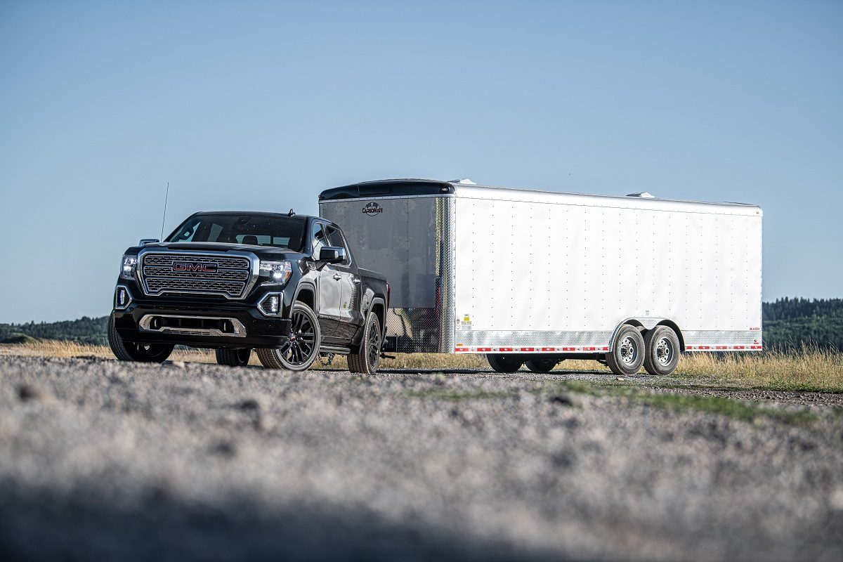 Front side view of 2021 GMC Sierra 1500 Denali pulling large trailer