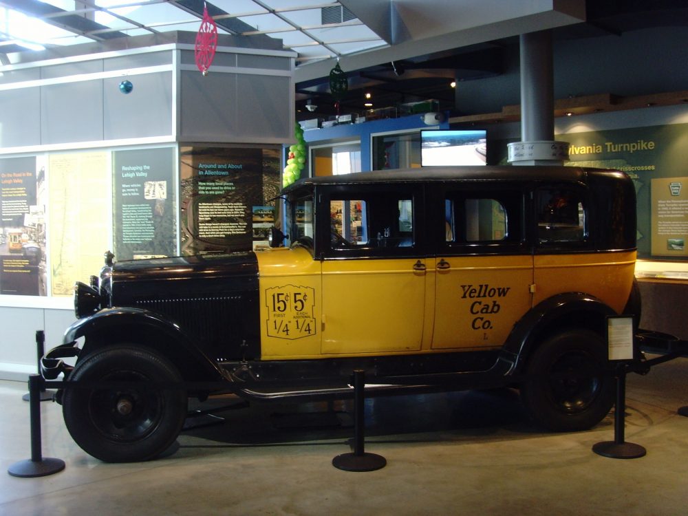 A 1930 Yellow Coach taxi on display in a museum, sitting in far better condition than the one you drive in Mafia.