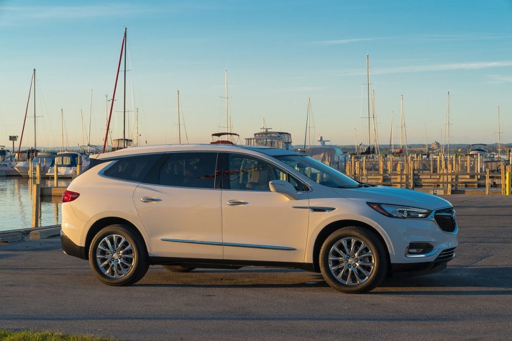 Side view of Buick Enclave parked next to harbor and boats