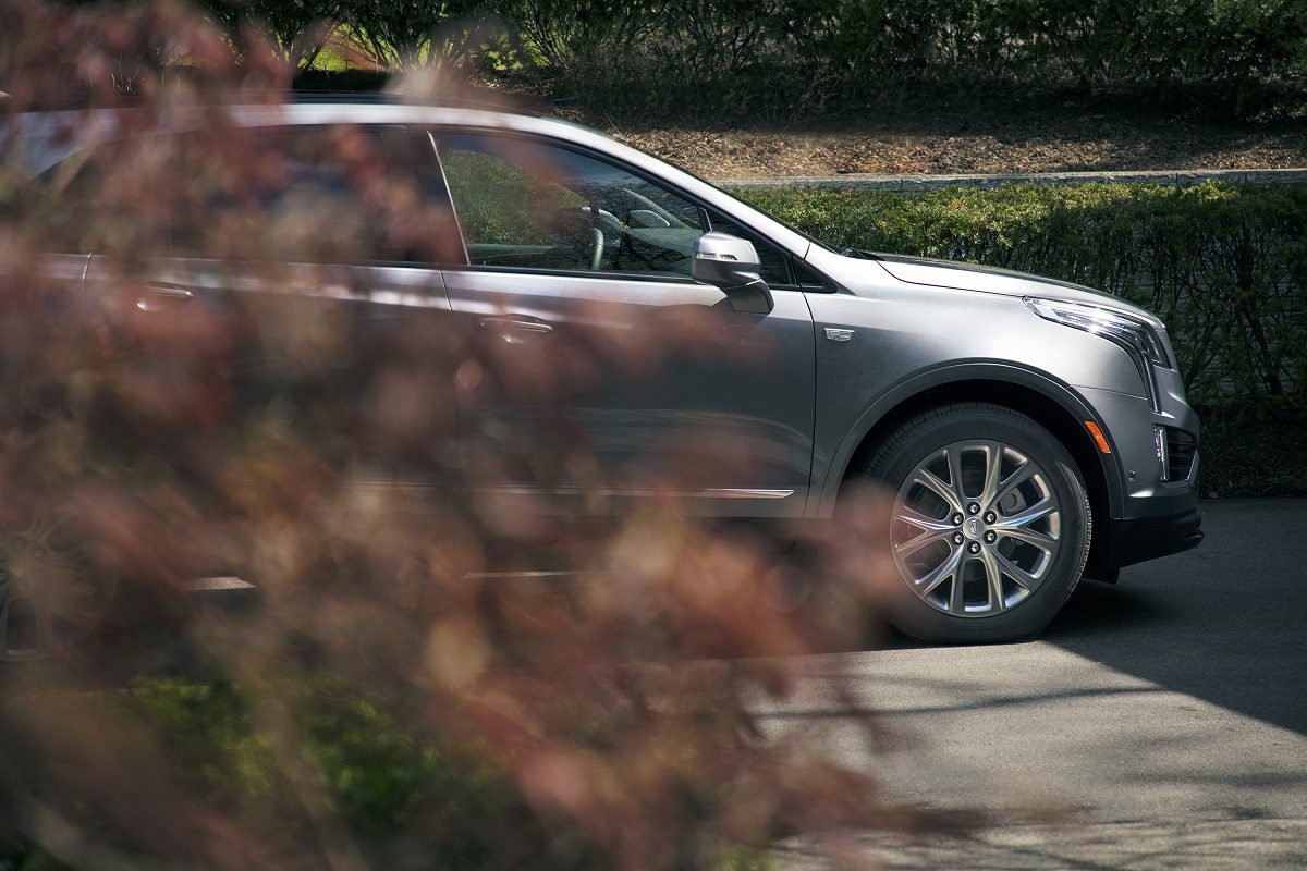 Partial side view of Cadillac XT5 through bushes