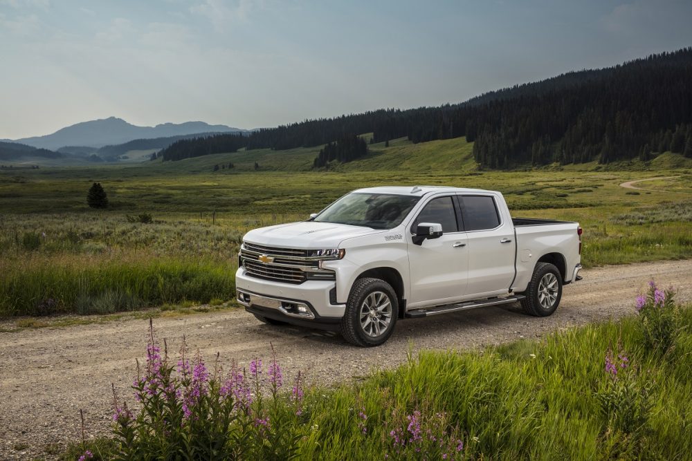 Front side view of Chevrolet Silverado 1500 High Country driving down dirt road