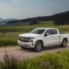 Front side view of Chevrolet Silverado 1500 High Country driving down dirt road