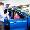 Customer and dealer salesperson go over a Ford Blue Advantage Gold Certified vehicle