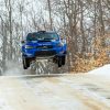 a Subaru WRX STI jumping a hill during the 2021 Sno*Drift Rally race