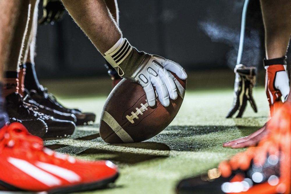 close up of football player hands and ball