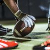 close up of football player hands and ball