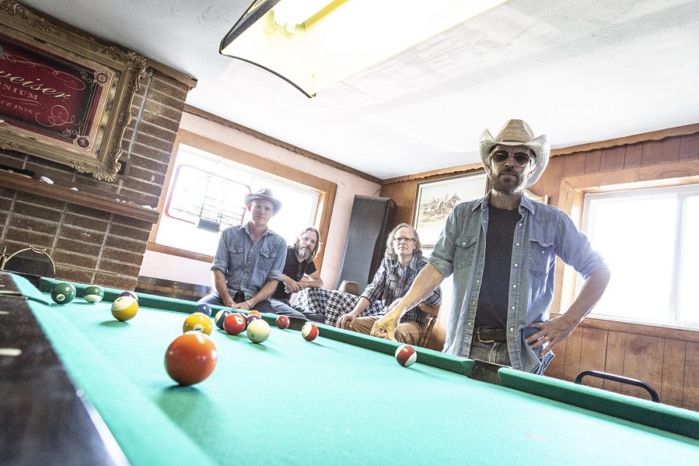 Bottle Rockets band members posed behind pool table