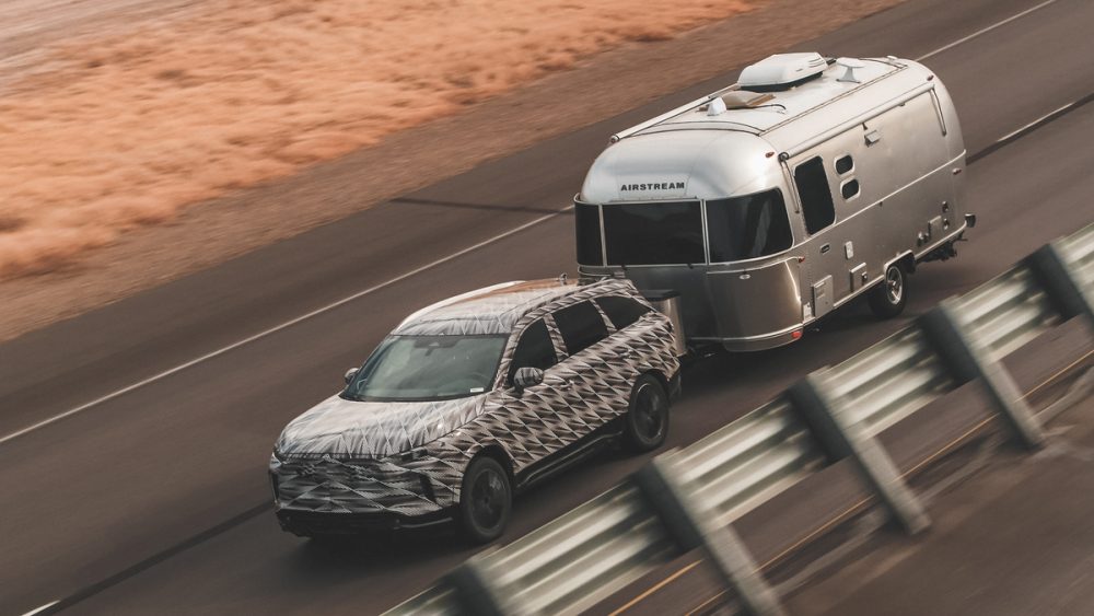 INFINITI QX60 towing an Airstream RV on the road