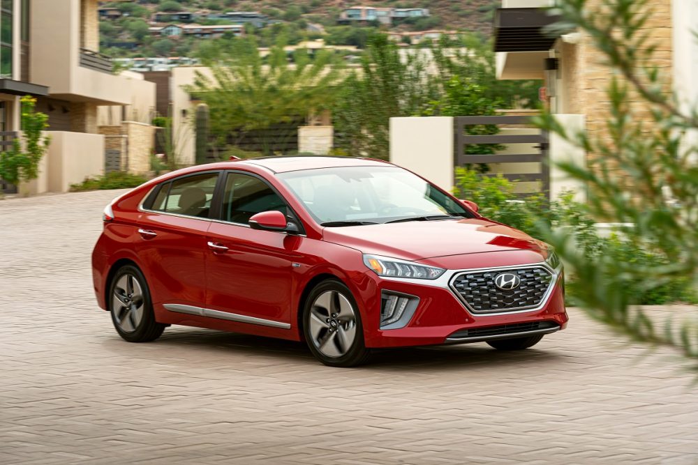 Front side view of red 2021 Hyundai Ioniq Hybrid parked on a brick driveway