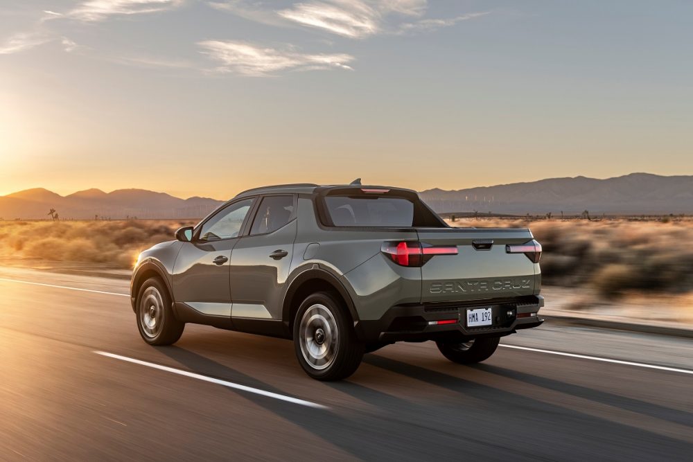 Rear side view of 2022 Hyundai Santa Cruz driving down road