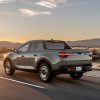 Rear side view of 2022 Hyundai Santa Cruz driving down road