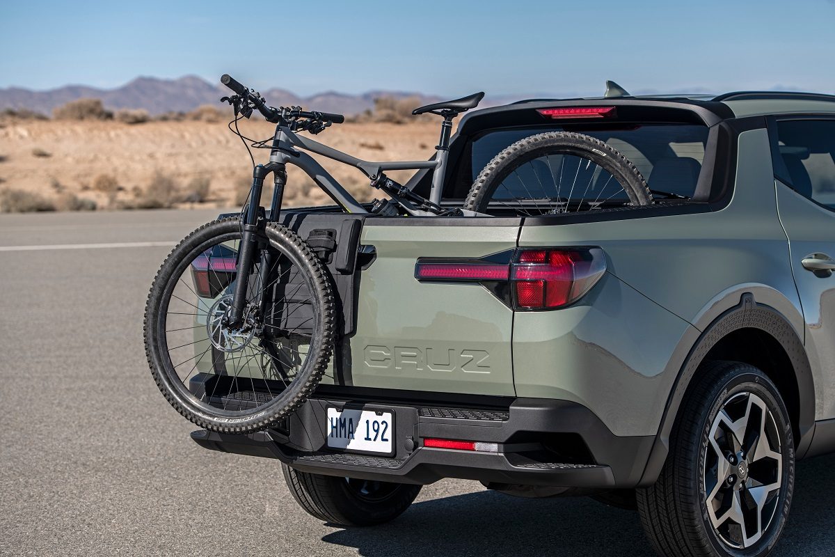 Rear side view of 2022 Hyundai Santa Cruz bed with bicycle hanging out