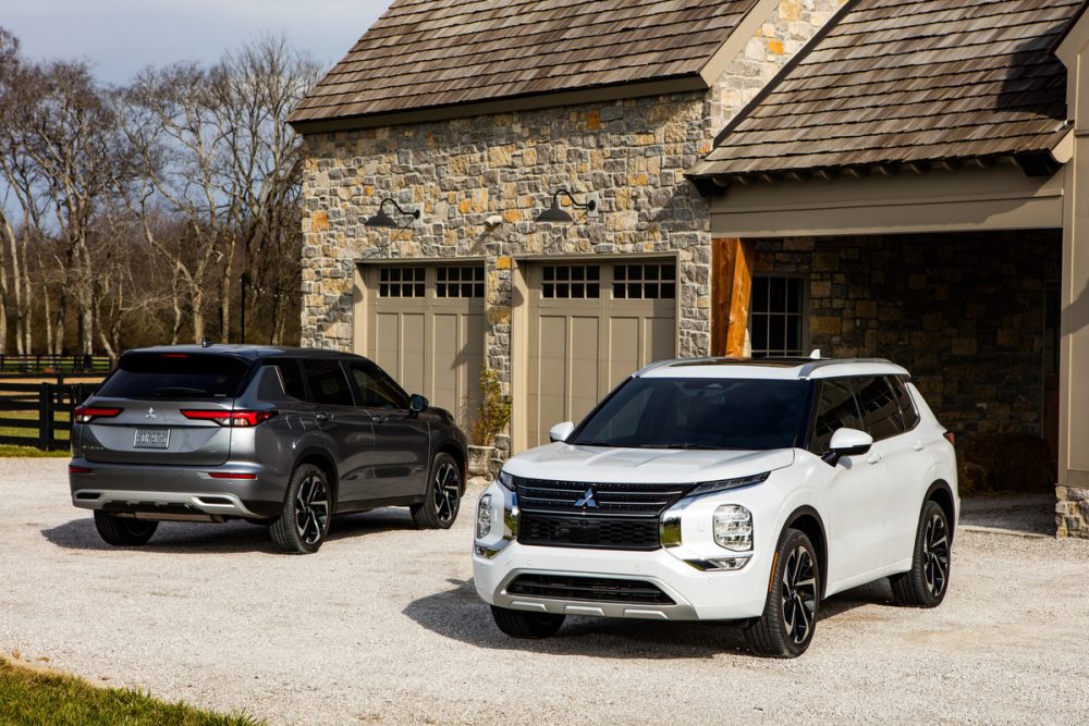 Two 2022 Mitsubishi Outlander models parked in front of a house