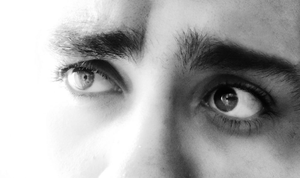 A black and white image of eyes staring wistfully into the distance