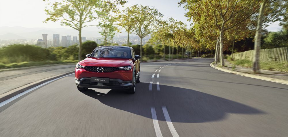 2022 Mazda MX-30 front view driving away from a city