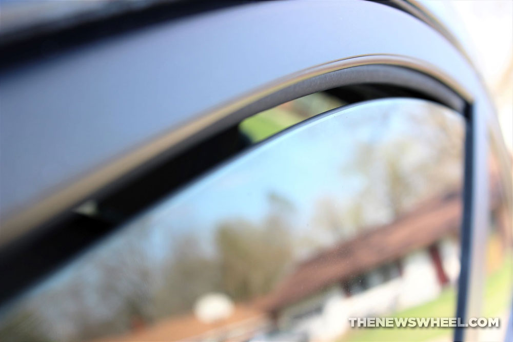 tinted car window partially rolled down with gap