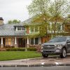 A 2021 Ford F-150 sat in the driveaway of an expensive-ish-looking house