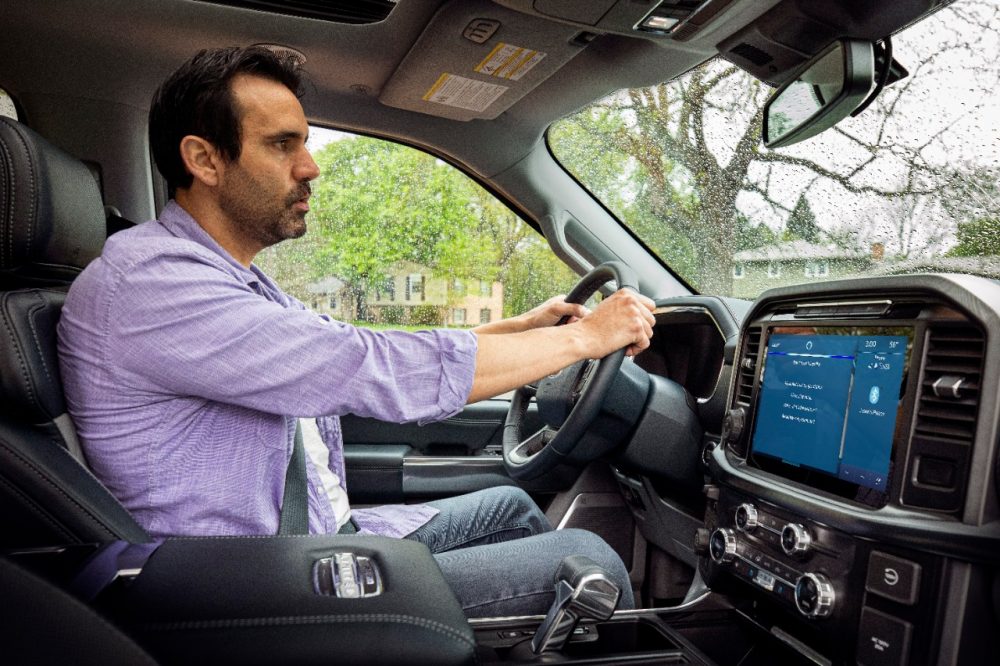 A fella in a purple shirt uses the Amazon Alexa voice command function in a new 2021 Ford F-150