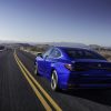 Rear view of a blue 2022 Lexus ES driving down a road