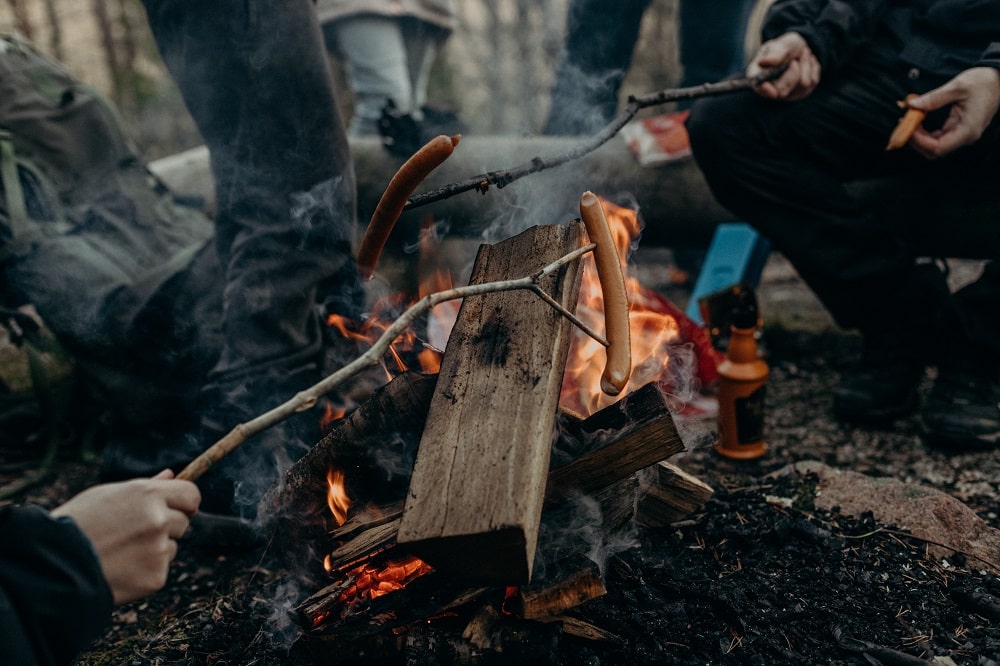 Grilling wieners over a campfire