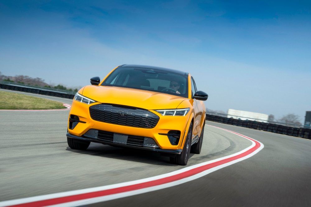 2021 Ford Mustang Mach-E GT Performance Edition in Cyber Orange rounding a corner on the track