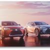 Red and silver 2021 Lexus UX models parked side by side in front of a sunset