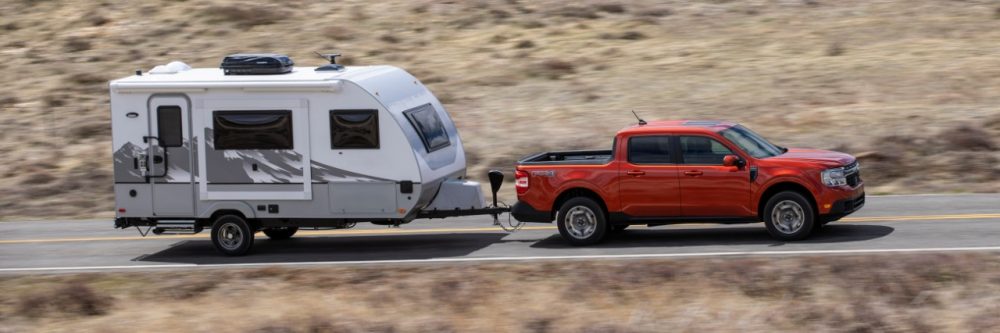 2022 Ford Maverick Lariat with 2.0-liter EcoBoost AWD in Hot Pepper Red towing a camper