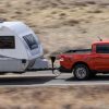 2022 Ford Maverick Lariat with 2.0-liter EcoBoost AWD in Hot Pepper Red towing a camper