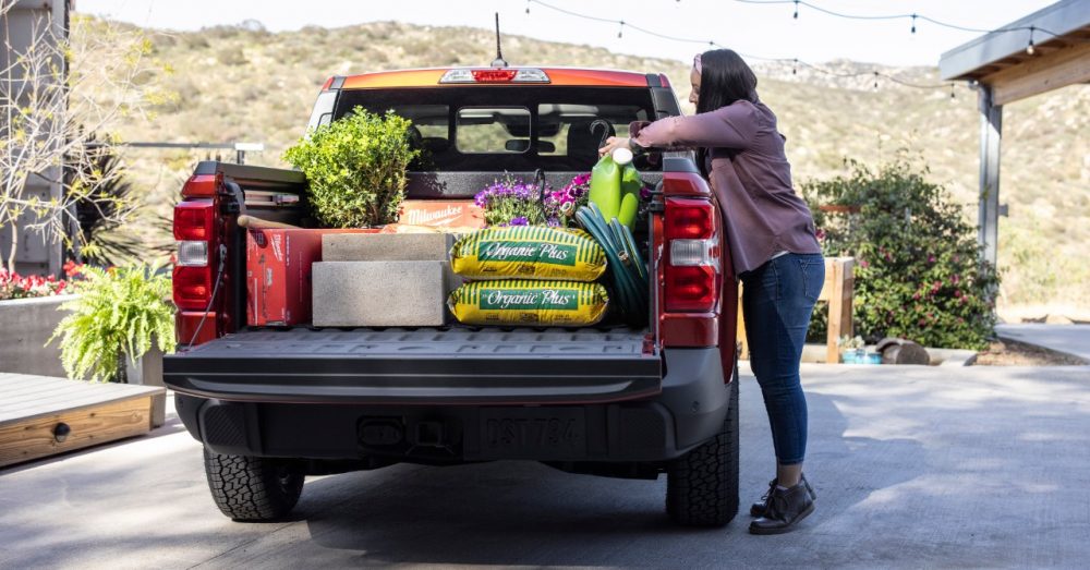 2022 Ford Maverick Lariat with 2.0-liter EcoBoost AWD in Hot Pepper Red with several gardening items being stored in the FLEXBED