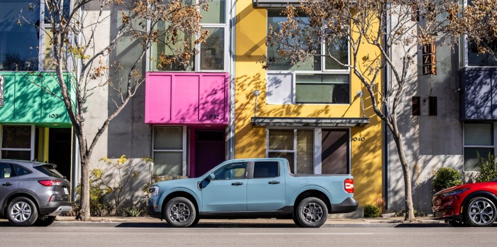 2022 Ford Maverick XLT in side profile parked on a street between an Escape and Mustang Mach-E 