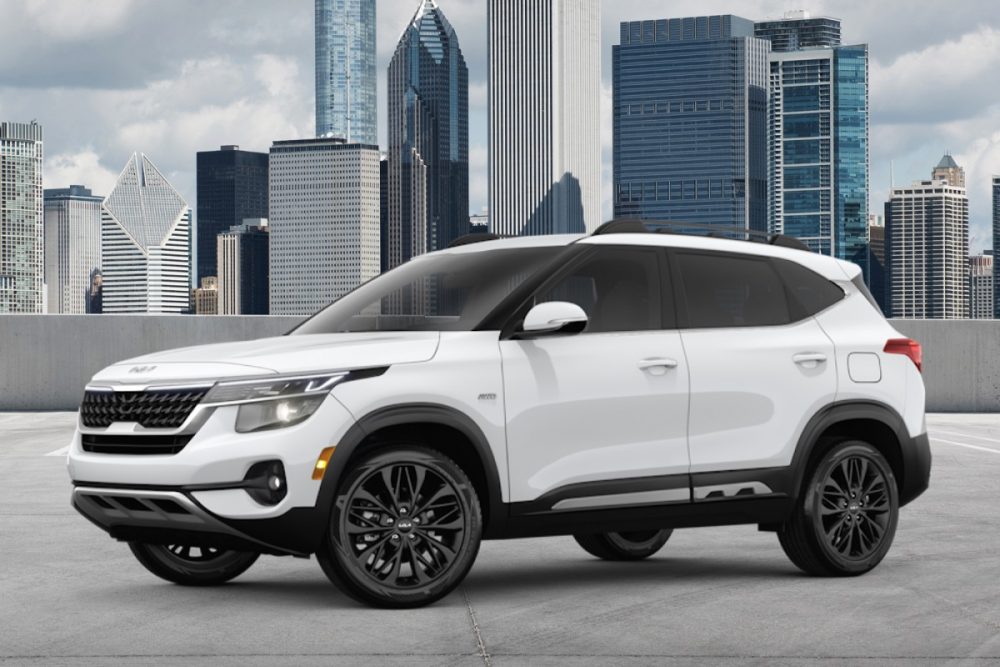 Outdoor photo of a white 2022 Kia Seltos Nightfall Edition in front of a city skyline