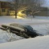 Black sedan stuck in a snowy ditch