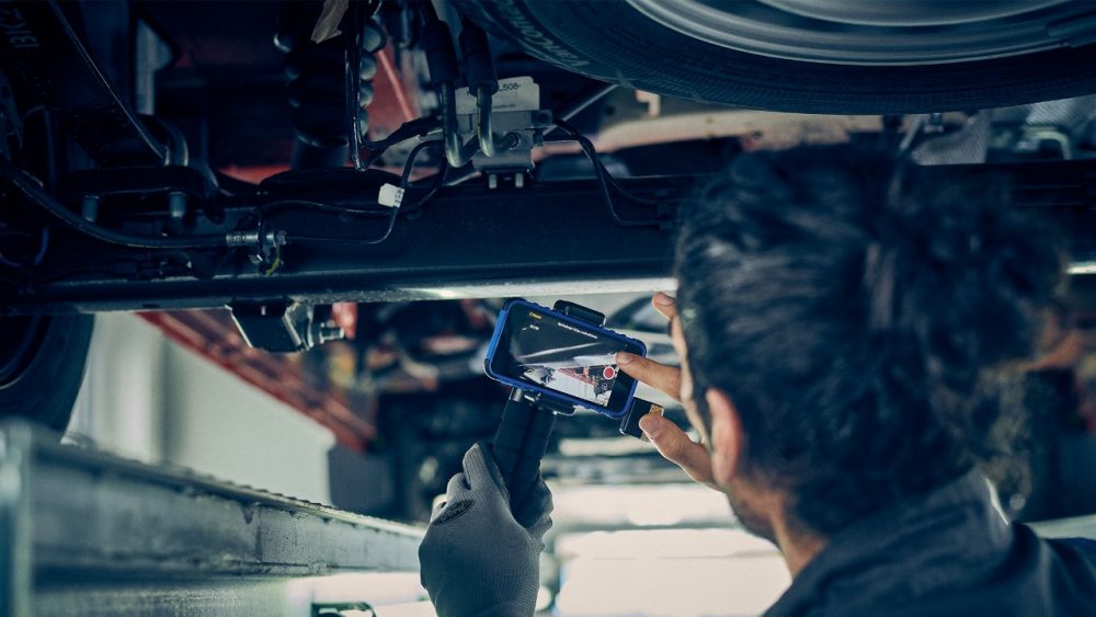 Ford Service Pro technician performing a video check under a vehicle
